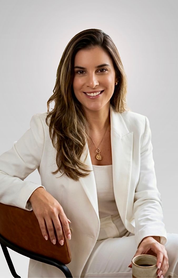 Adriana Telis, nutricionista, sentada com uma xícara de café nas mãos